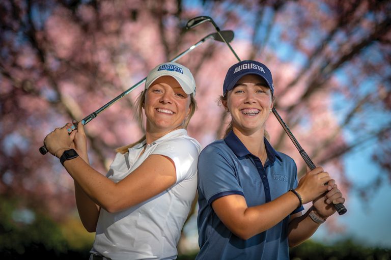Two women holding golf clubs
