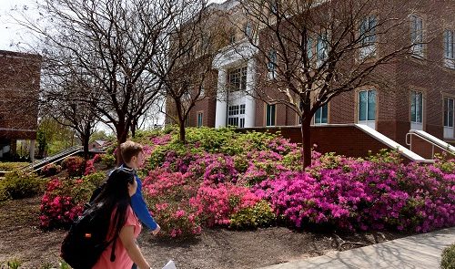 Two students walking in front of a building
