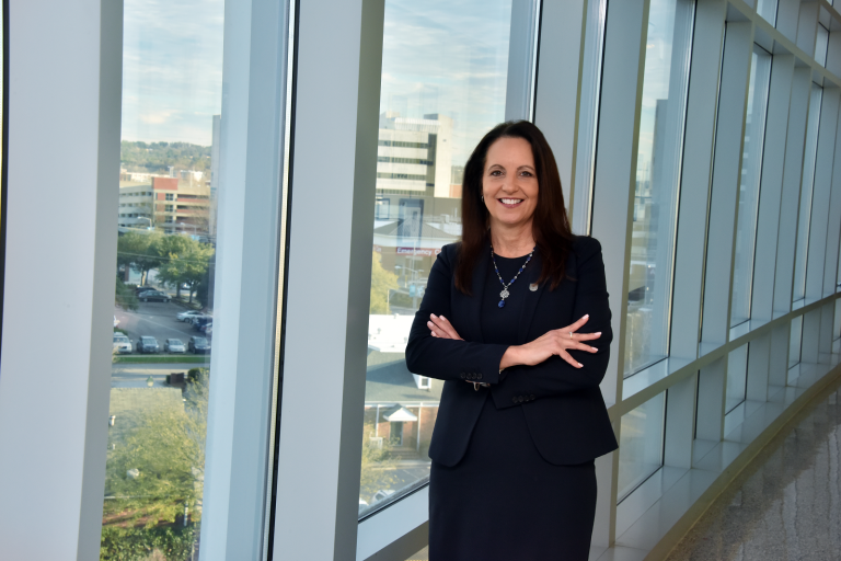 woman in dark suit standing by window