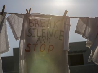 T-shirt on a clothesline that reads "BREAK SILENCE AND STOP"