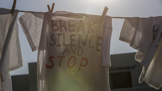 T-shirt on a clothesline that reads "BREAK SILENCE AND STOP"