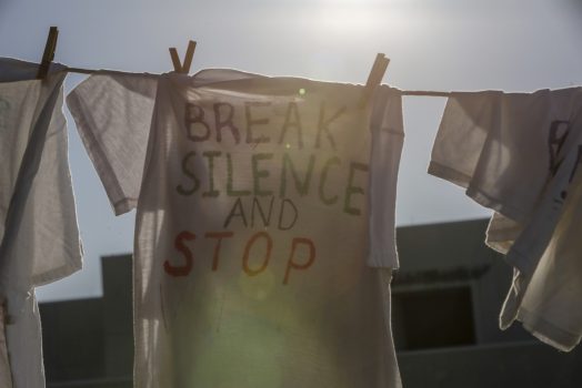 T-shirt on a clothesline that reads "BREAK SILENCE AND STOP"
