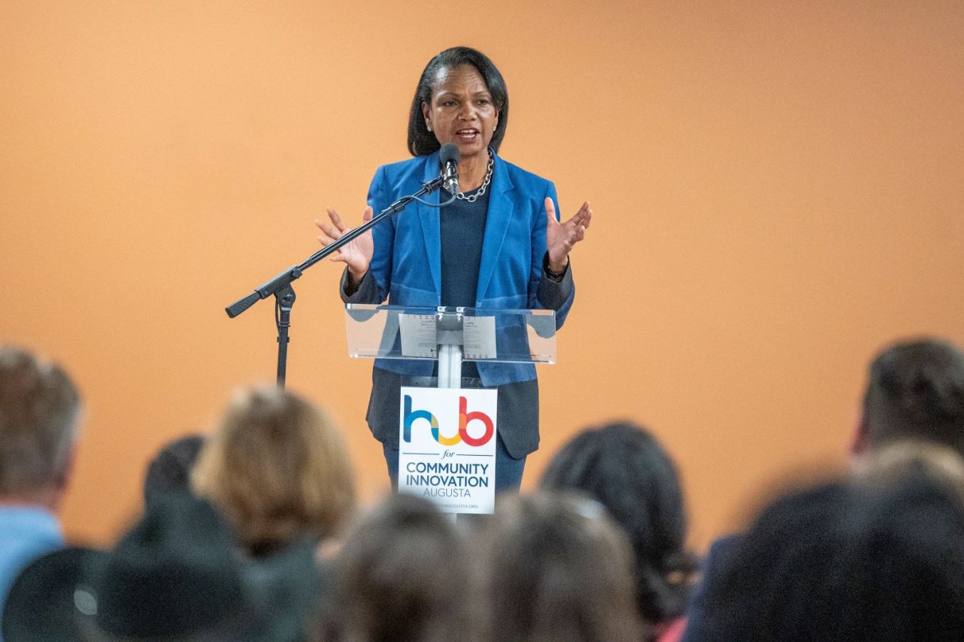 woman in blue suit speaking to crowd