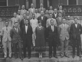 one woman stands for class photo with group of men
