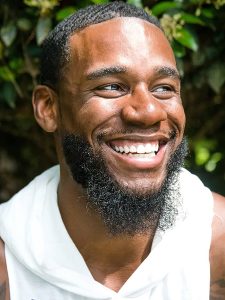man with beard smiling outside