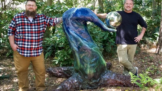 two people standing by sculpture