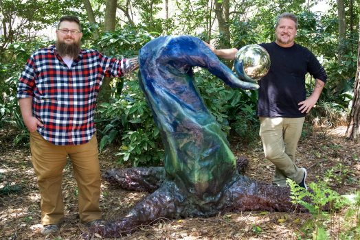 two people standing by sculpture