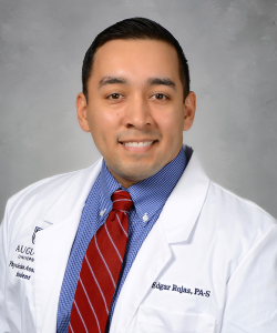 man wearing a tie and lab coat smiling