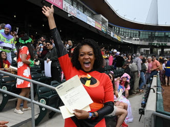 woman in superhero uniform cheering in crowded stadium