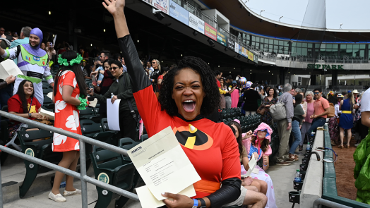 woman in superhero uniform cheering in crowded stadium