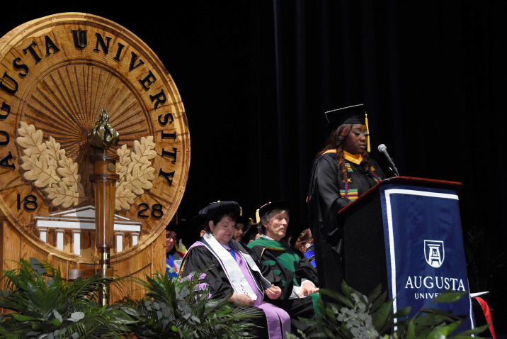 woman speaking at podium at graduation