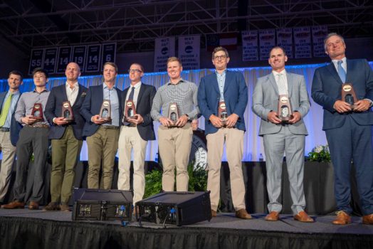 Men standing with trophies