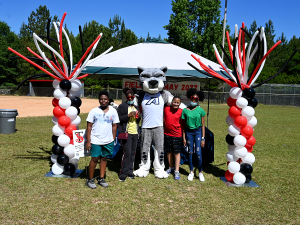 children standing in a field with a mascot