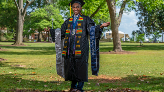 man smiling in cap and gown