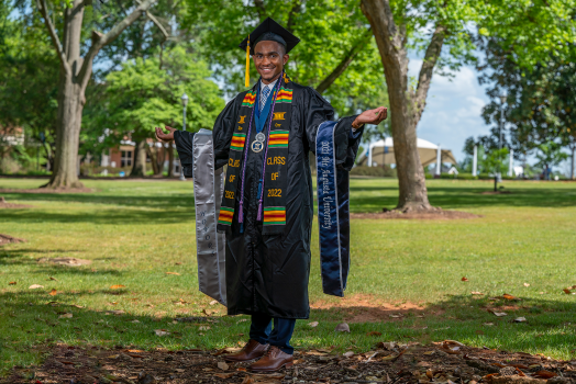 man smiling in cap and gown