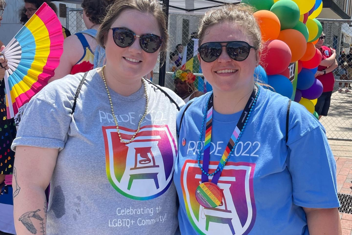 two people in Pride-themed Augusta University T-shirts