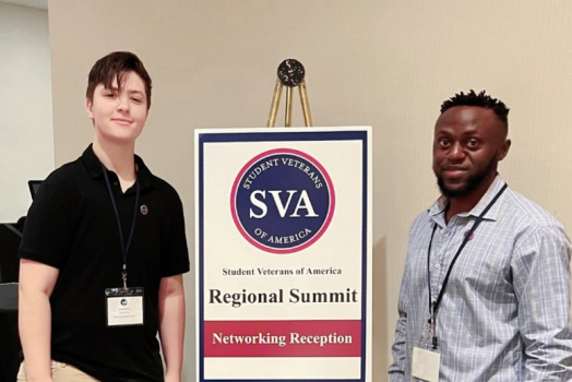 two men in front of a conference sign