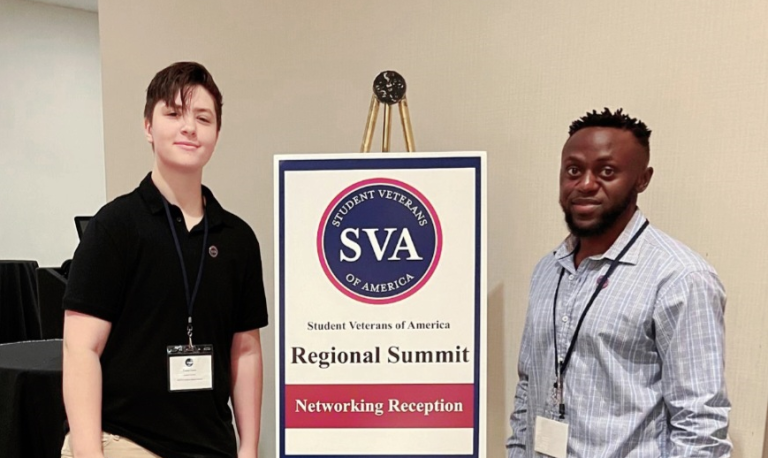 two men in front of a conference sign
