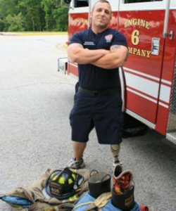 man standing with arms crossed in front of fire truck