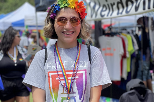 person wearing flower headband and Pride-themed Augusta University T-shirt