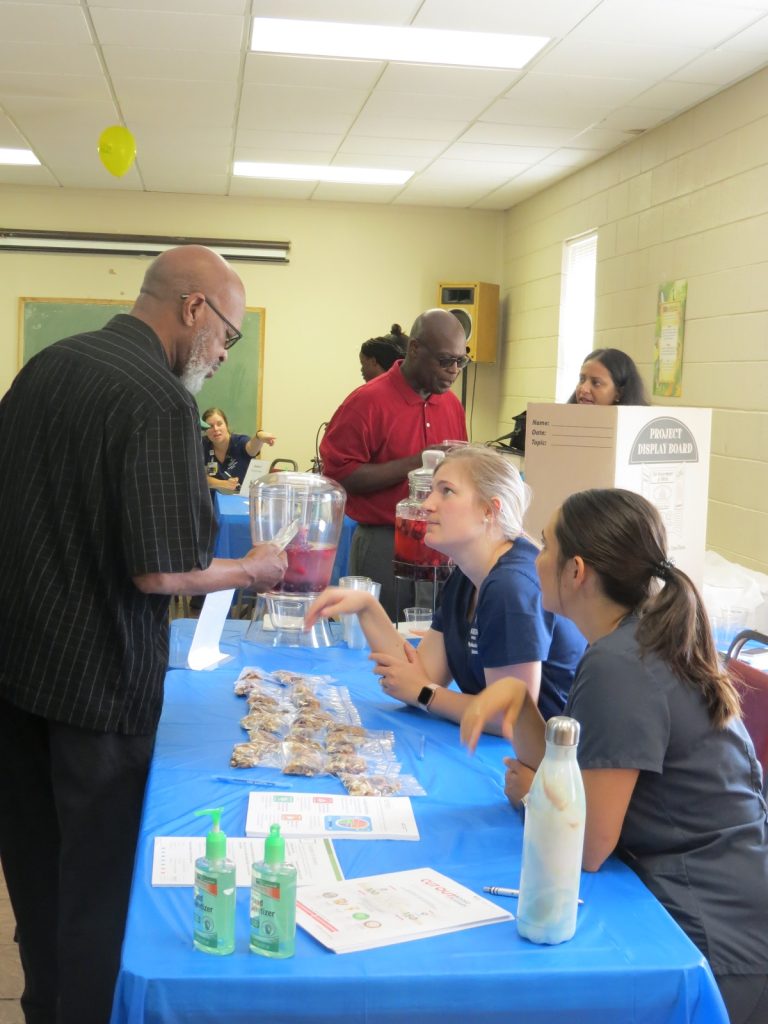 men and women talking at a health fair