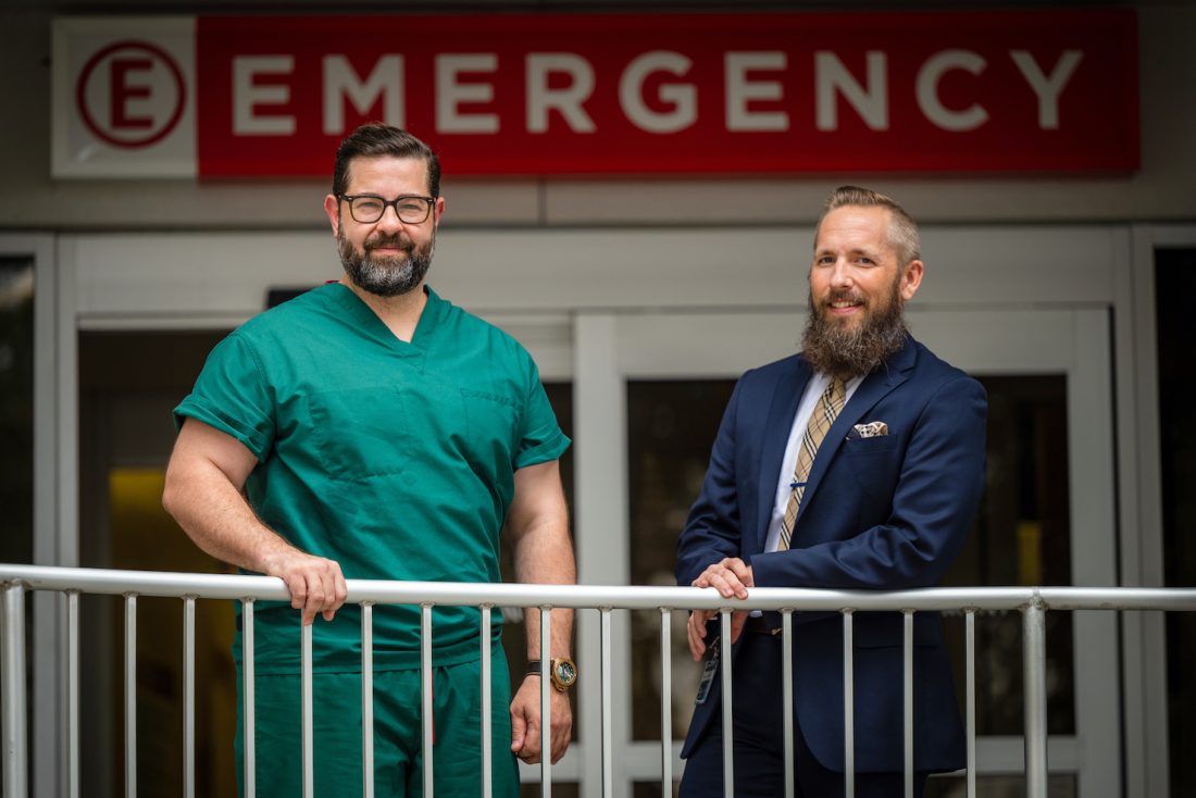 Two men standing by the Emergency Room