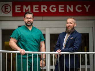 Two men standing by the Emergency Room