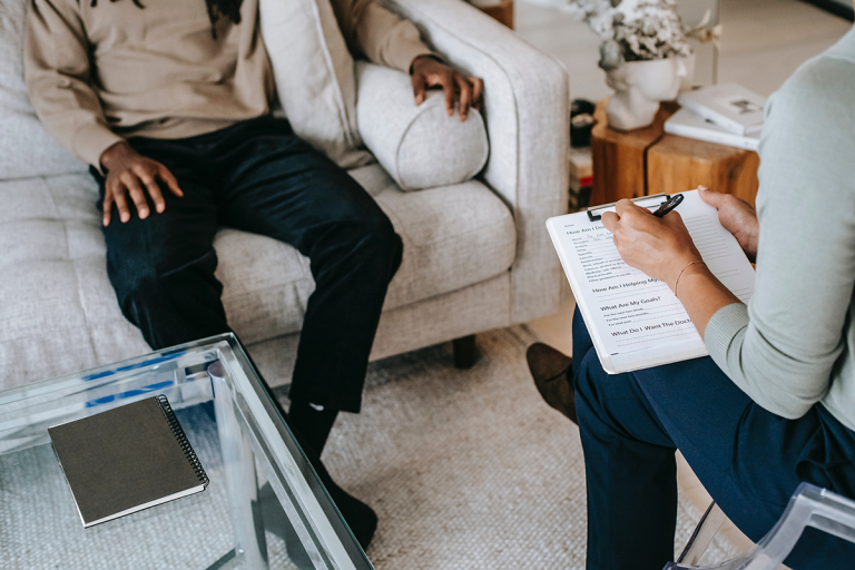 man sitting across from person holding clipboard and pen