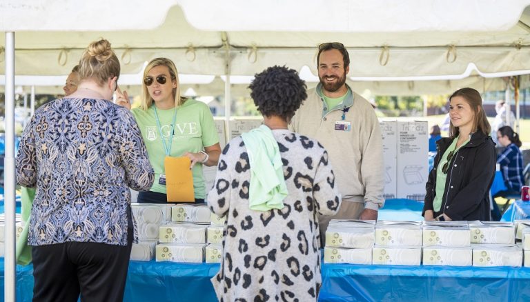 five employees gathered at tent