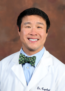 man in white coat and bowtie, smiling
