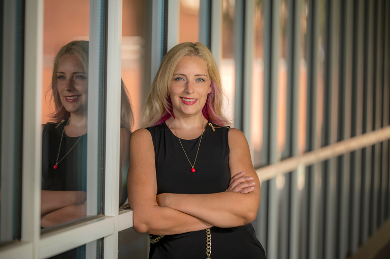 woman with arms crossed leaning against wall