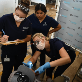 three dental health care providers work with a patient