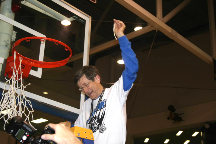 Man cutting down basketball net
