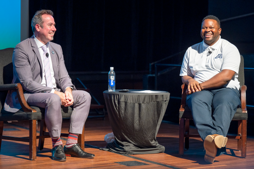 two men on stage talking