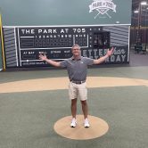 Man stands on indoor baseball field