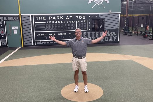 Man stands on indoor baseball field