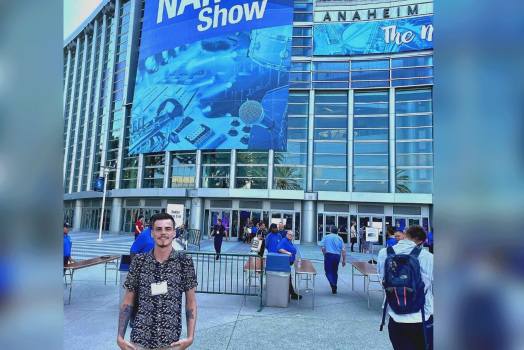 student standing in front of a convention center