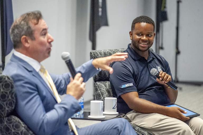 two men holding microphones during an interview
