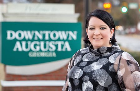 woman smiling in front of Downtown Augusta sign