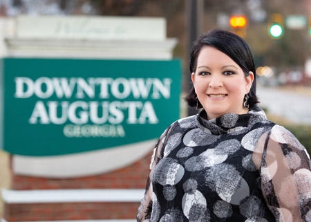 woman smiling in front of Downtown Augusta sign