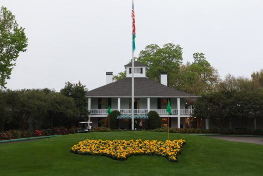 Building on golf course with flowers and flag pole
