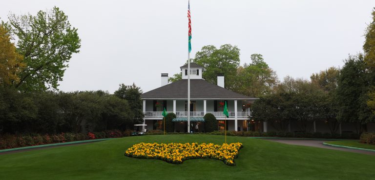 Building on golf course with flowers and flag pole