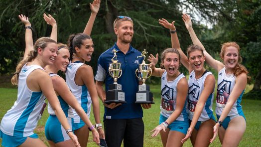 Women celebrating with man holding trophies