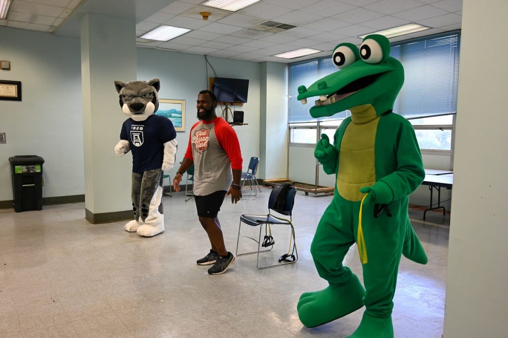 Fitness trainer exercises with two mascot