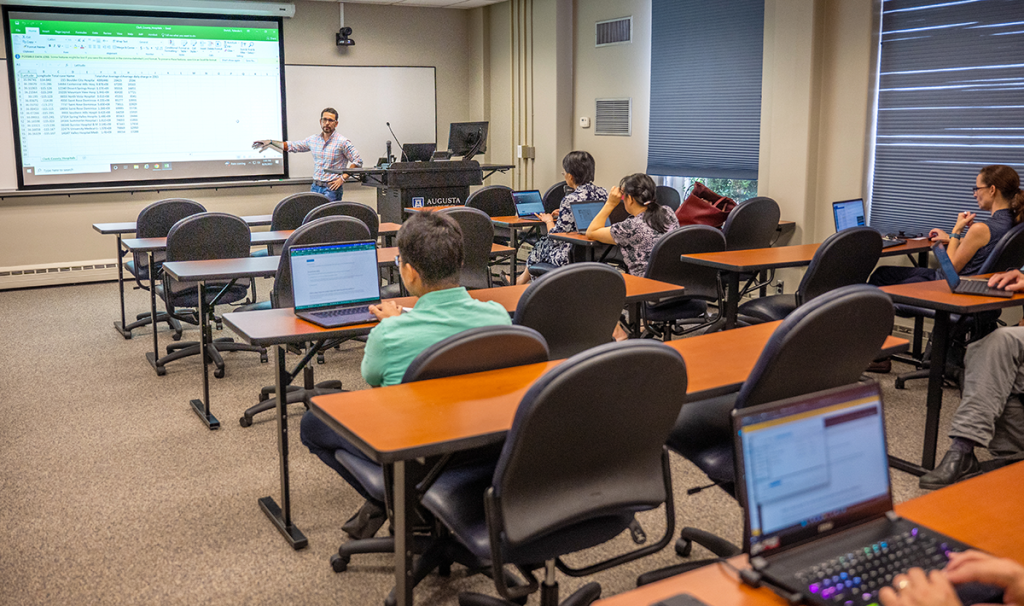 Man presents to a group of people in a classroom