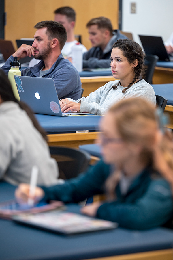 students sit at lab tables in a lecture hall