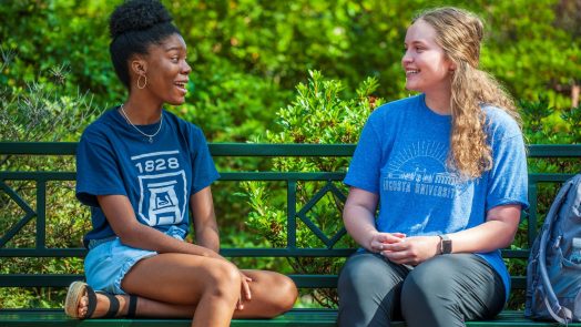 two women talking on a bench