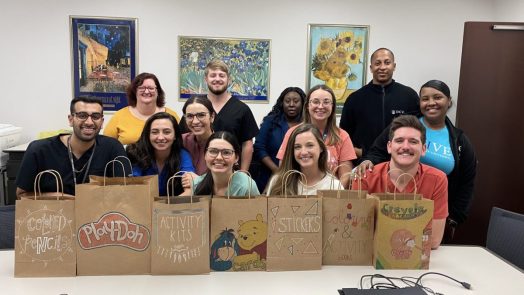 group of people standing in front of decorated brown paper bags