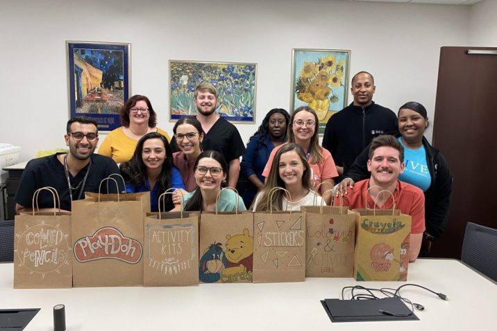 group of people standing in front of decorated brown paper bags
