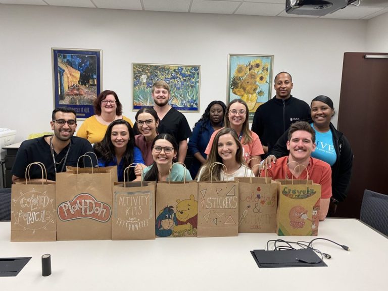 group of people standing in front of decorated brown paper bags